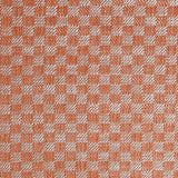 Close up of woven fabric with small scale checkerboard pattern in white and bright orange. 