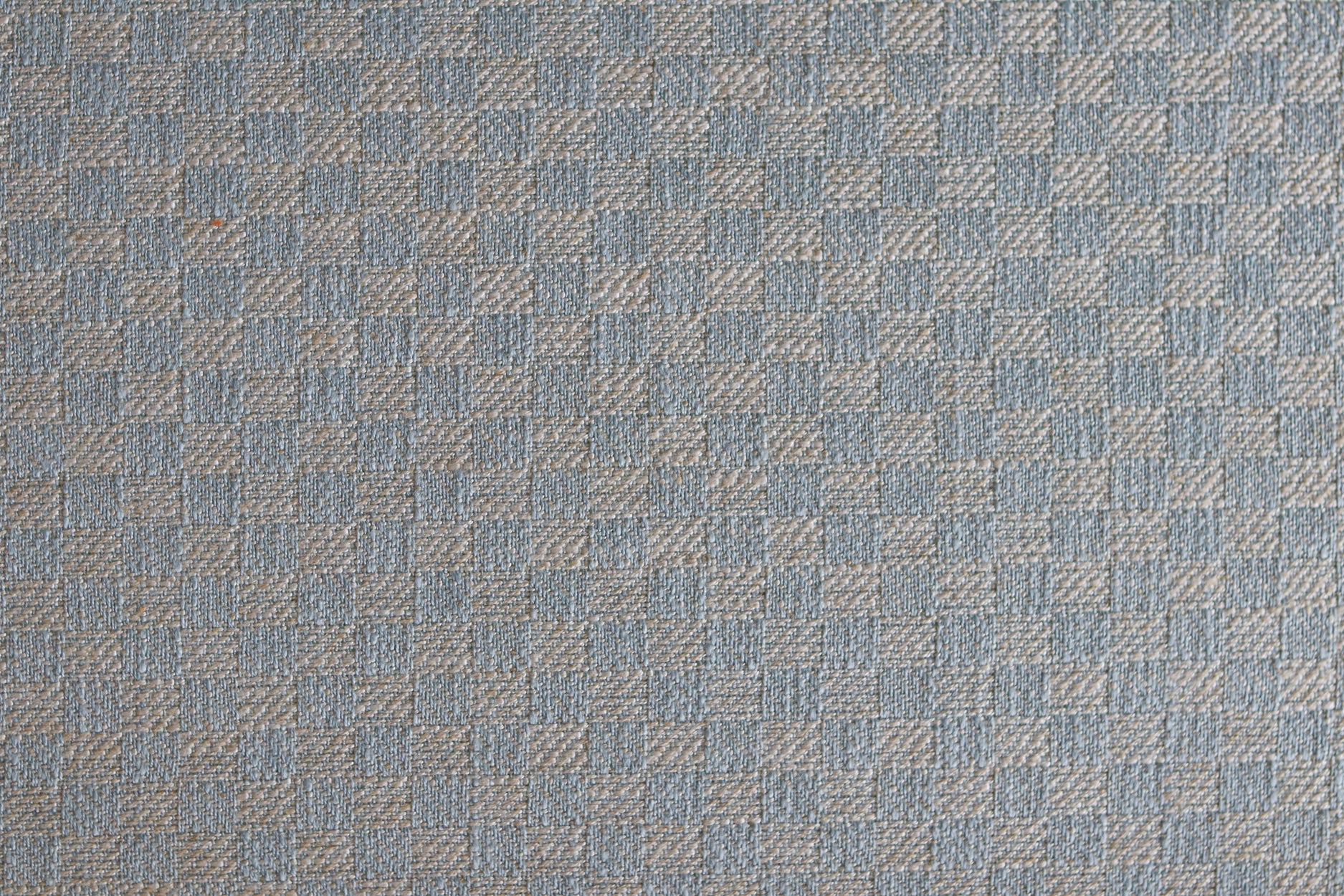 Close up of woven fabric with small scale checkerboard pattern in white and pastel blue.