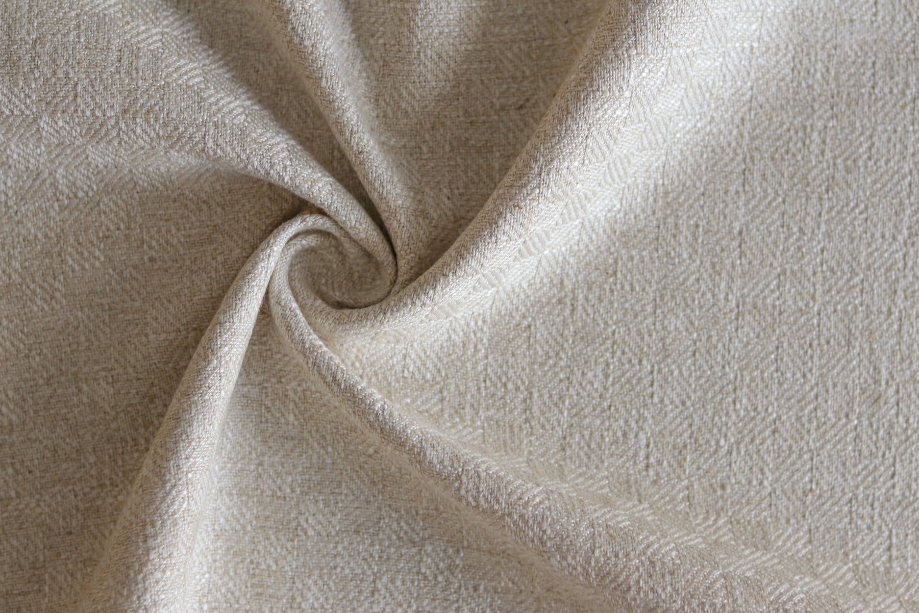Close up of draped woven fabric with small scale checkerboard pattern in white and beige.