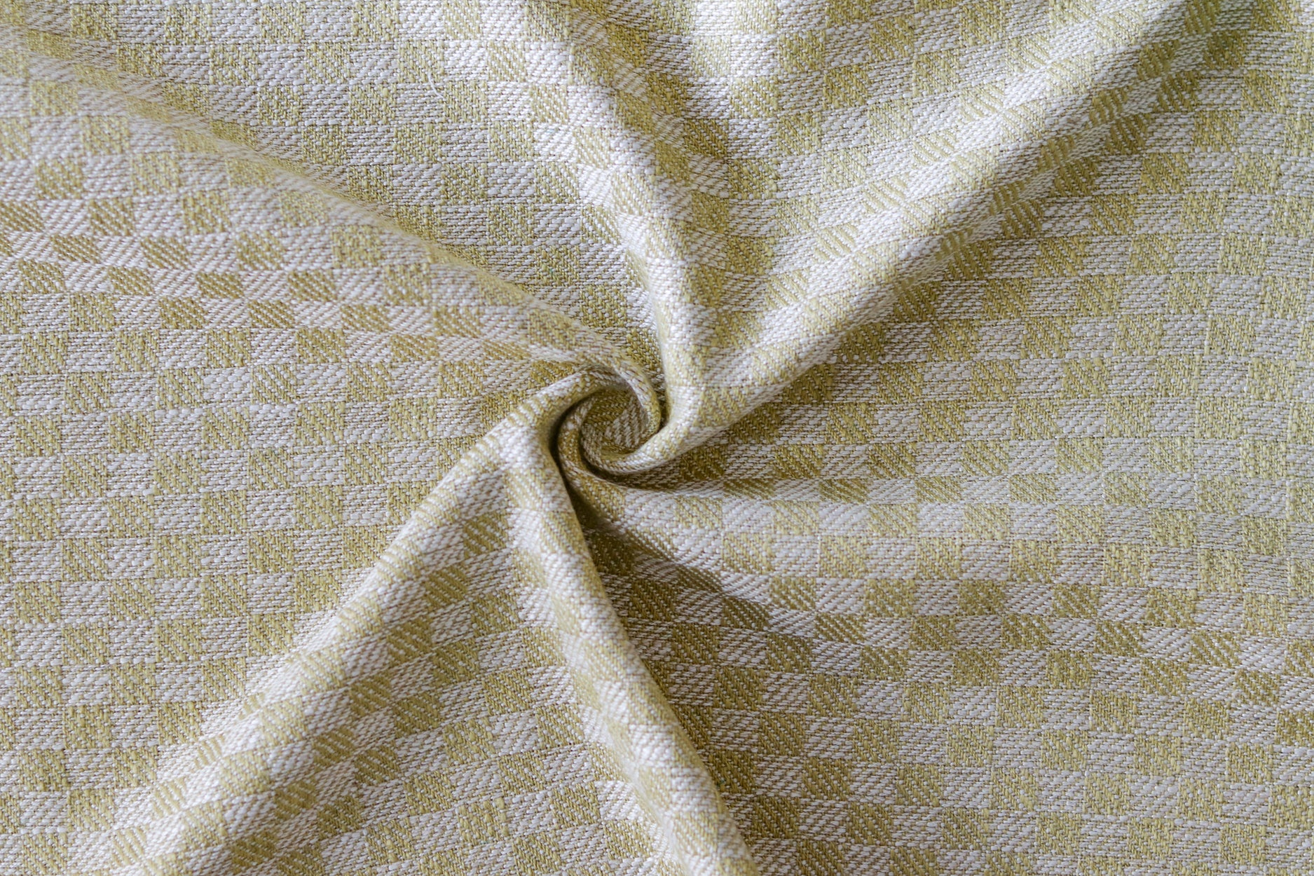 Close up of draped woven fabric with small scale checkerboard pattern in white and pale green. 