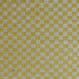 Close up of woven fabric with small scale checkerboard pattern in white and yellow.