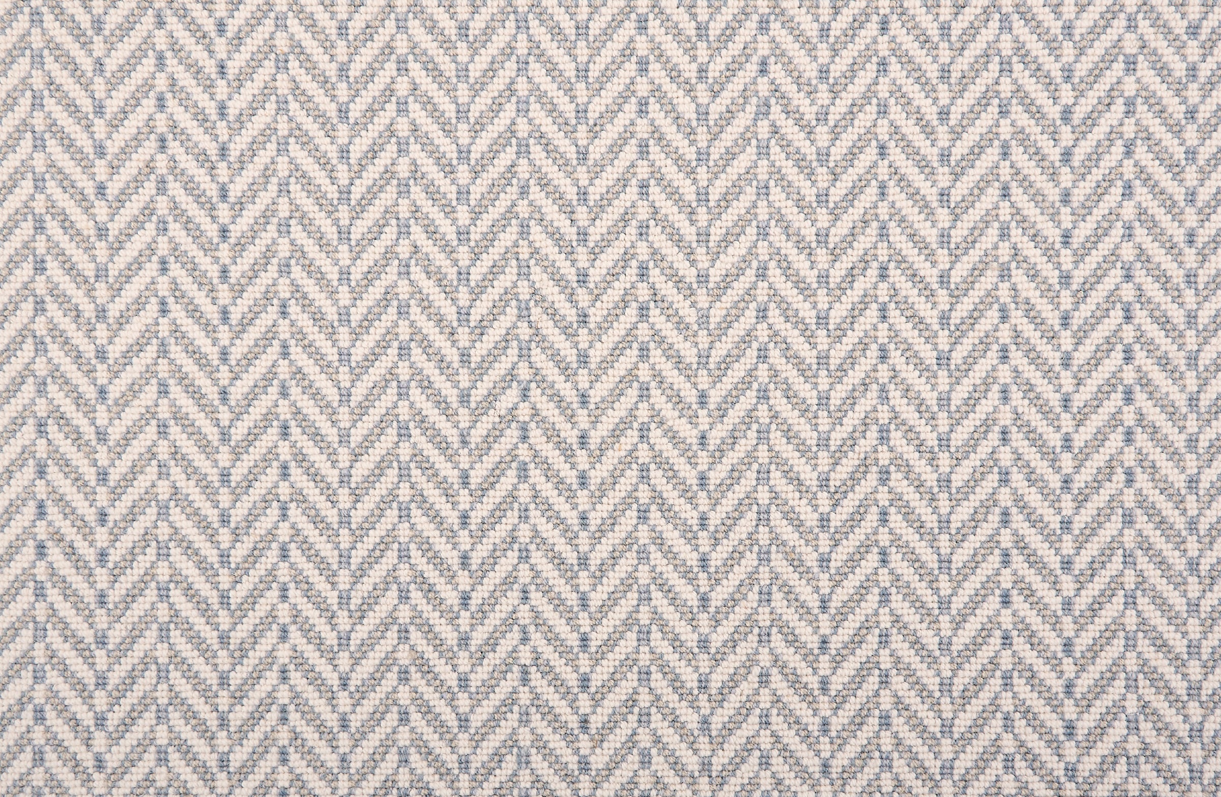 Broadloom carpet in a herringbone pattern pastel blue and white. 