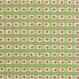 Detail of fabric in a playful dotted check print in pink and green on a cream field.