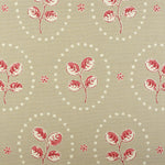Detail of fabric in a repeating leaf print in red and cream on a light brown field.