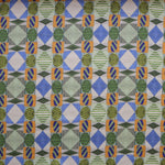Close up of printed fabric with collaged pattern with striped and solid diamonds, squares and ovals in blue, green, orange and white. 