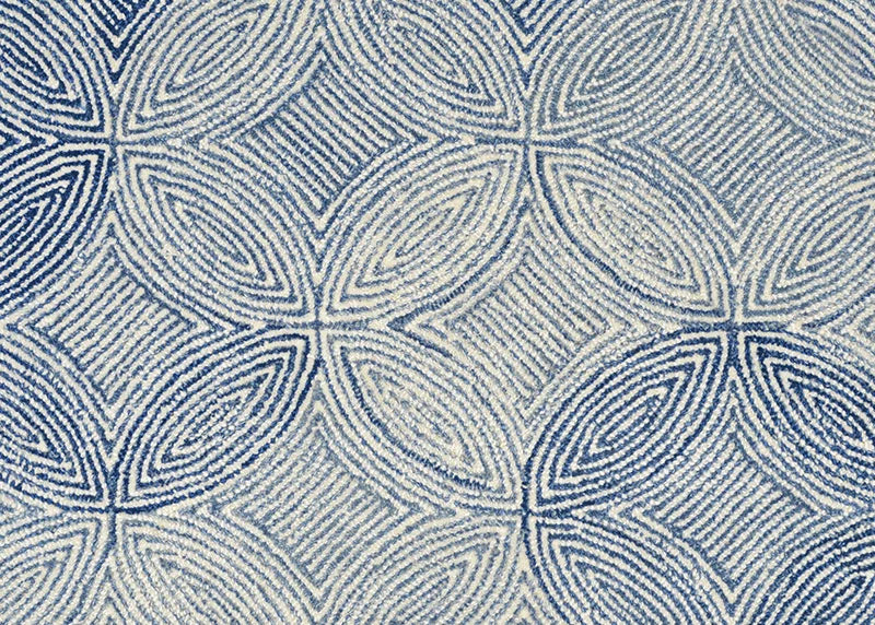 Broadloom carpet in a circular mosaic design in dense stripes of white and blue.