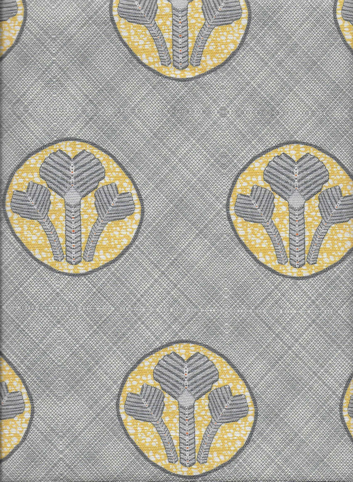 Detail of fabric in a repeating curvilinear floral print in yellow and gray on a gray field.