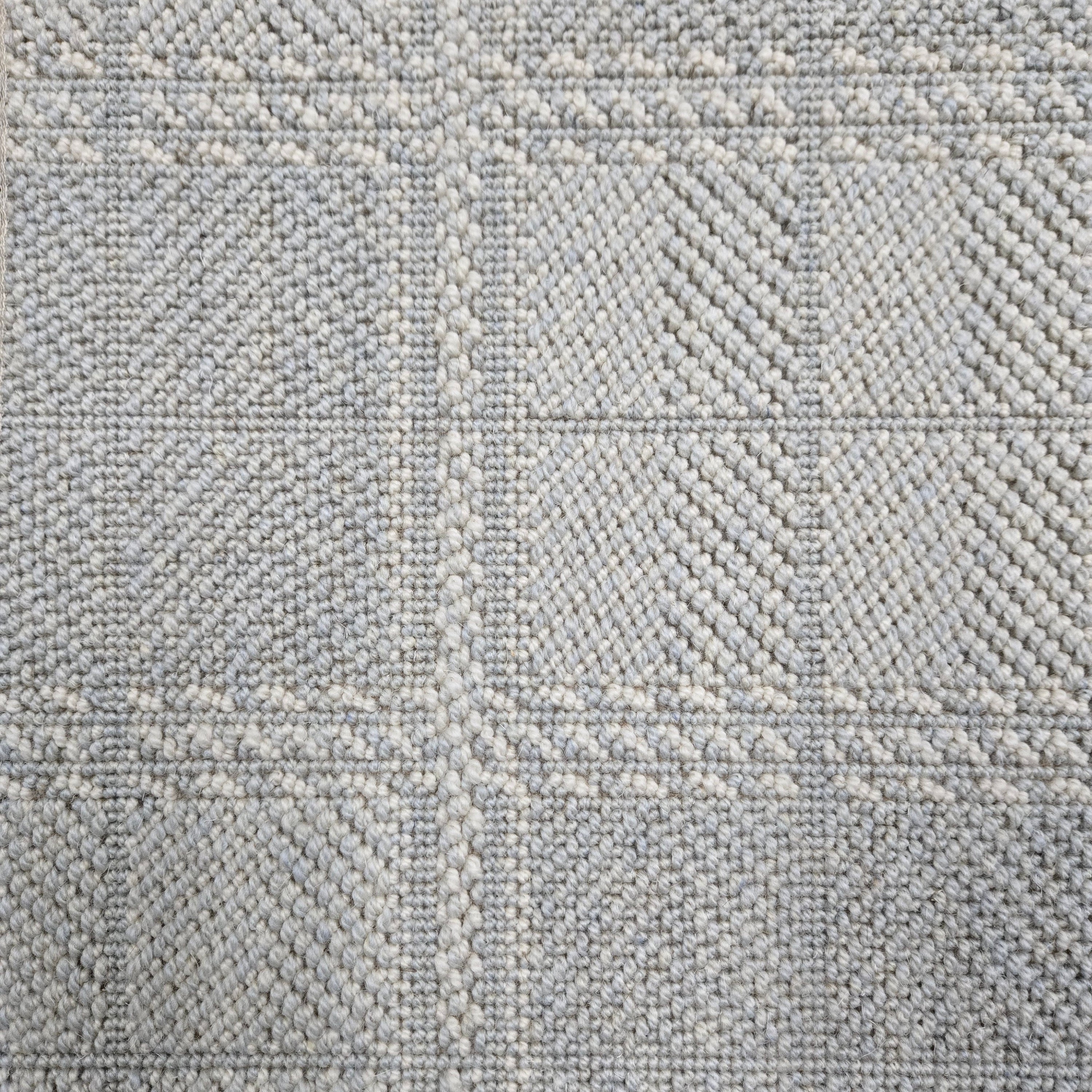 Broadloom carpet in wide box checkerboard pattern in light blue and cream. 