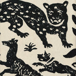 Detail of wallpaper in a playful animal print in black on a cream field.