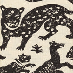 Detail of fabric in a playful animal print in black on a cream field.