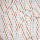 Close up of gently draped woven Indoor-Outdoor fabric with small scale geometric ditsy print in coral and light blue on white. 