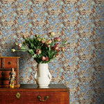 Blue and Brown floral wallpaper with a vase of flowers on a wooden dresser