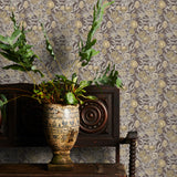 Decorative wallpaper with brown floral pattern, wooden cabinet with plants, and ornate vase.