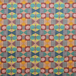 Close up of printed fabric with a complex geometric pattern with pink, red, blue, yellow, orange and turquoise.