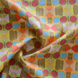 Close up of gently draped printed fabric with a complex geometric pattern with red, blue, orange and green. 