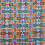 Close up of printed fabric with a complex geometric pattern with blue, orange, green, pink and red. 