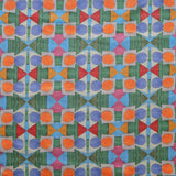 Close up of printed fabric with a complex geometric pattern with blue, orange, green, pink and red. 