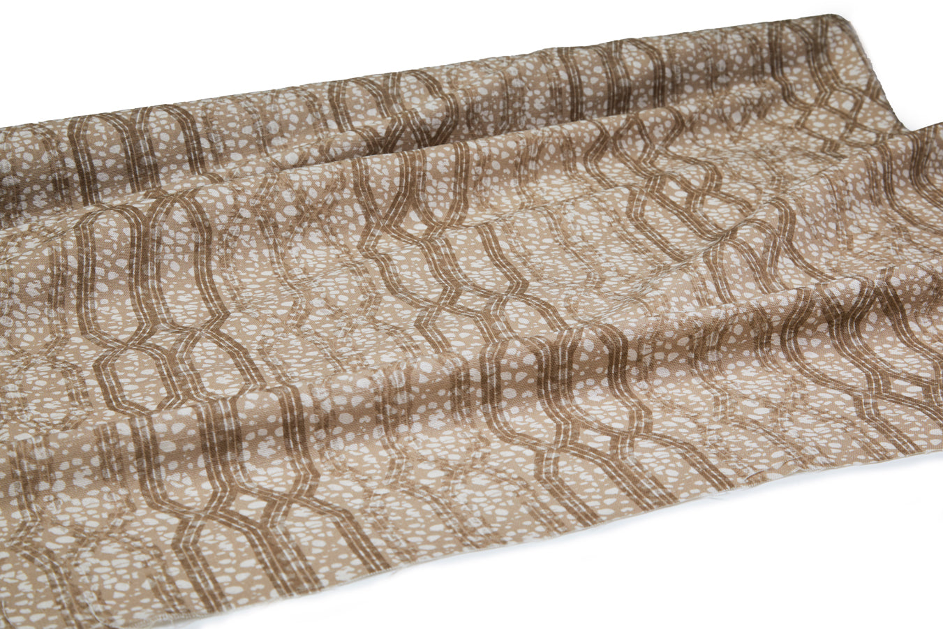 Draped fabric coming off a roll with monochomatic geometric stripe and mottled textural background in shades of  brown.