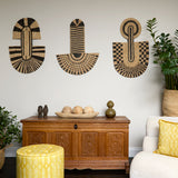 Living room scene with three black and tan sculptural woven panels, ornately carved wooden chest, baskets with house plans, white upholstered side chair and a stripe patterned footstool in yellow.