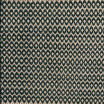 Handwoven wool rug with textural oval pattern in dark green on a beige field. 