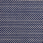 Handwoven wool rug with textural oval pattern in dark blue on a beige field. 