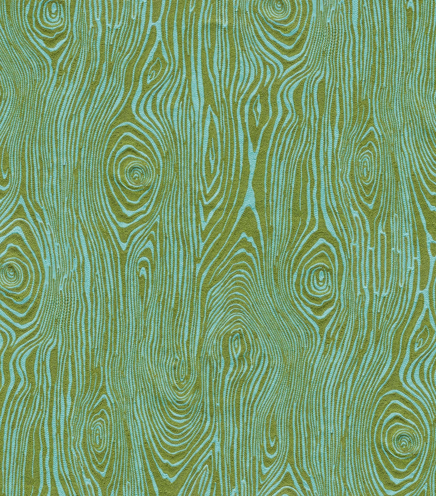 Detail of fabric in a textural wood grain print in green on a turquoise field.