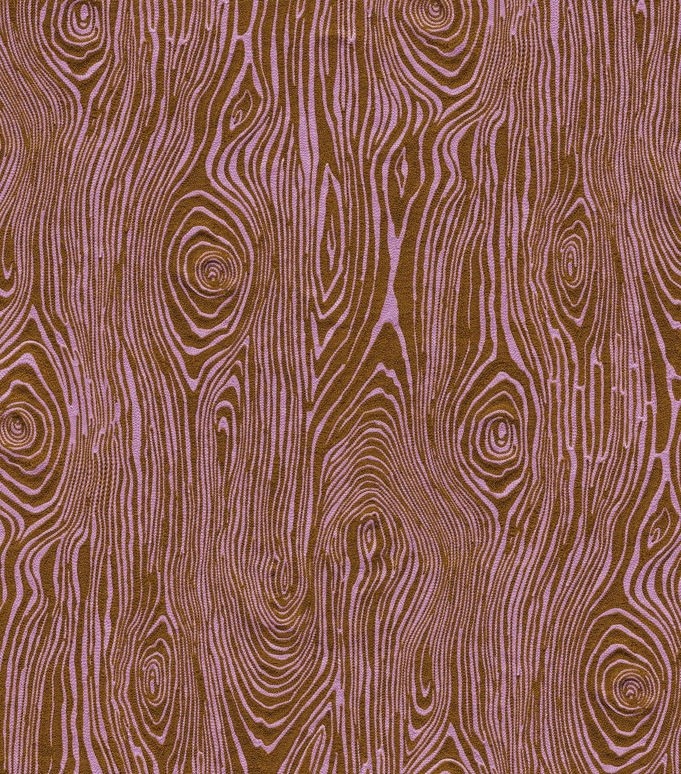 Detail of fabric in a textural wood grain print in purple on a brown field.