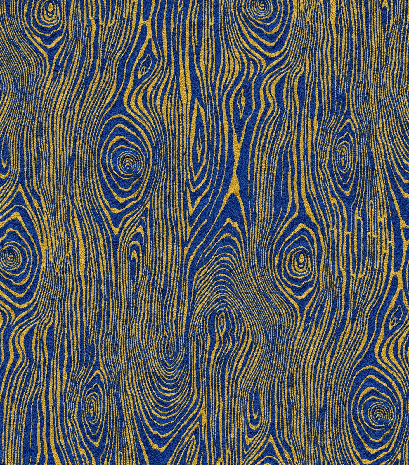 Detail of wallpaper in a textural wood grain print in yellow on a blue field.