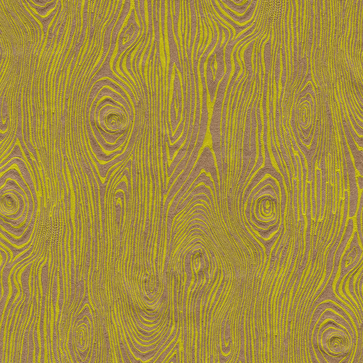 Detail of fabric in a textural wood grain print in tan on a yellow field.