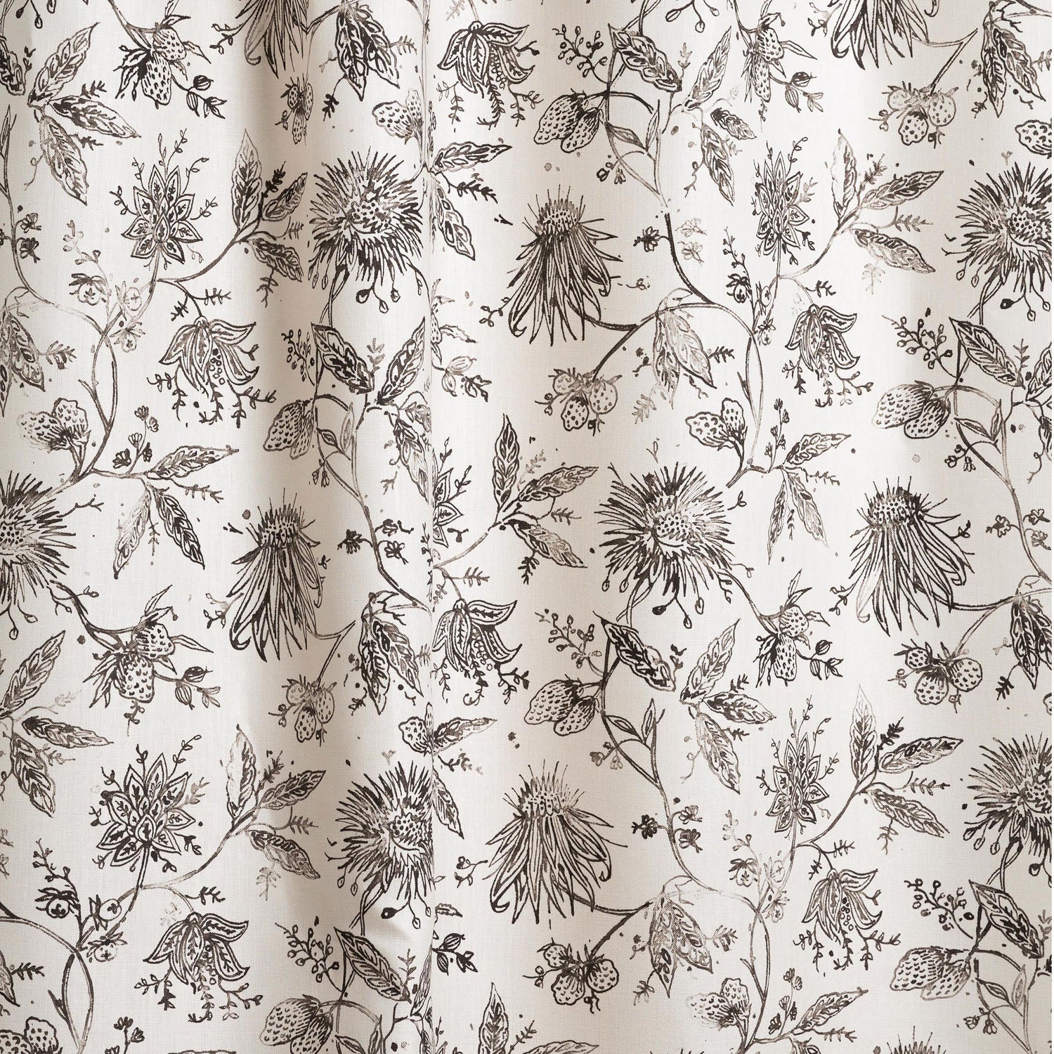 Draped fabric with watercolor floral pattern with black leaves and flowers on a cream background