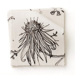 Fabric swatch with watercolor floral pattern with black leaves and flowers on a cream background