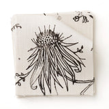 Fabric swatch with watercolor floral pattern with black leaves and flowers on a cream background