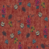 Detail of wallpaper in a varied floral print on a wood-grain field in shades of red, pink, yellow and green.