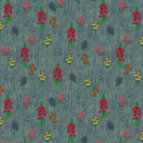 Scaled-out view of wallpaper in a varied floral print on a wood-grain field in shades of blue, red, yellow and green.