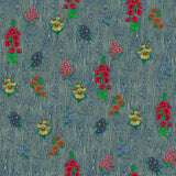 Detail of wallpaper in a varied floral print on a wood-grain field in shades of blue, red, yellow and green.