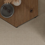 Overhead image of a angled wood coffee table over a beige broadloom carpet. 