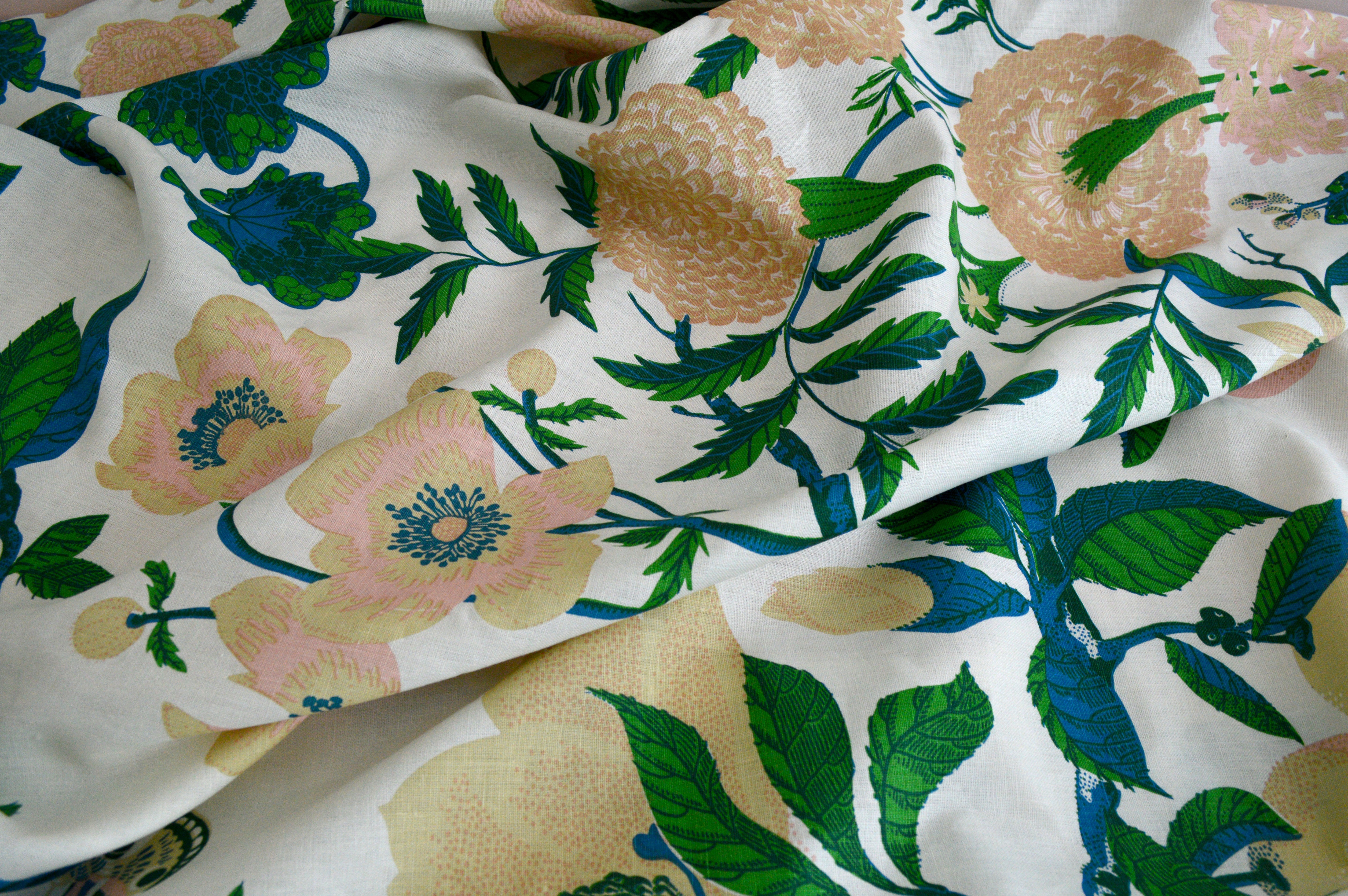 Floral fabric with green leaves and pink flowers on a white background