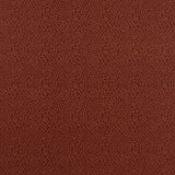 Detail of fabric in a minimalist wood grain print in tan on a rust field.