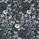 Detail of fabric in a dense floral print in white, tan and green on a black field.