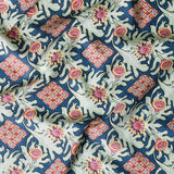 Draped fabric in a dense print mixing geometric and botanical motifs in blue, red, pale green and yellow