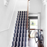 Striped flatweave runner in black and white on white staircase