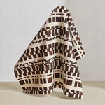 Draped fabric in a modernist checkerboard pattern in brown and cream.