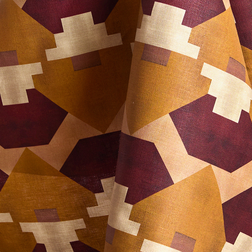 Draped fabric in a bold abstract checkerboard pattern in blush, oxblood, camel and cream.