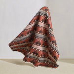 Hanging fabric in a complex stripe with geometric shapes and chevrons in clay, lilac, brown and cream.