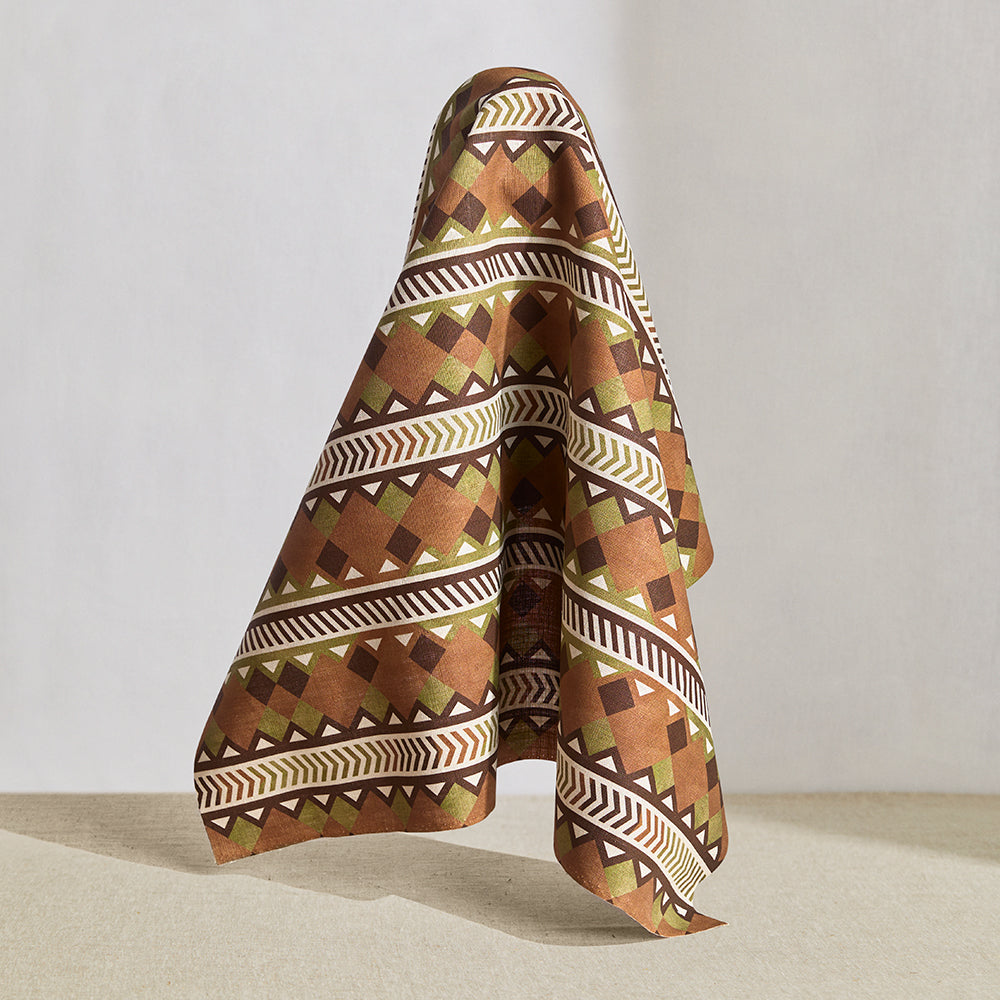 Hanging fabric in a complex stripe with geometric shapes and chevrons in clay, sage, brown and cream.