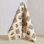 Hanging fabric in a graphic geometric pattern of circles, and stripes in black and grey on a cream field.