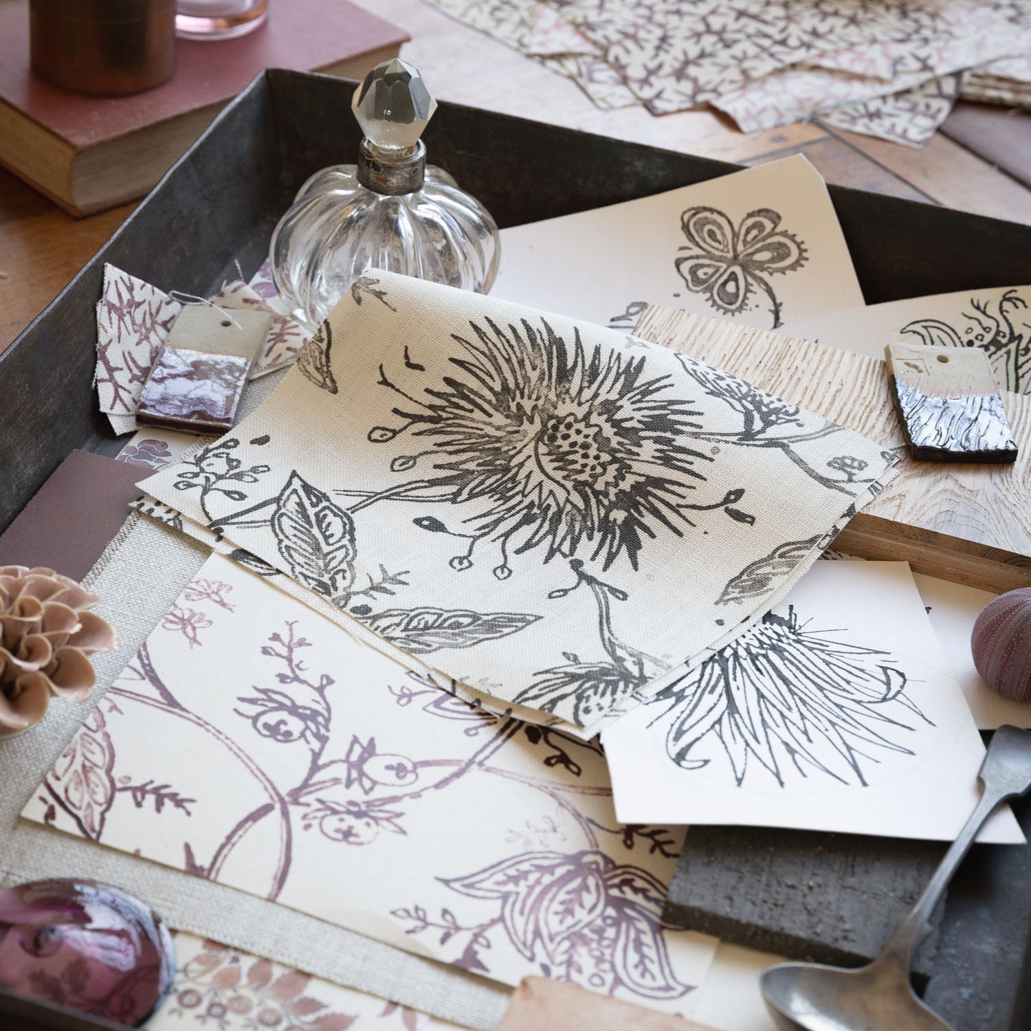 Desk scene with layers of watercolor floral swatches in various colors with natural specimens and vintage props. 