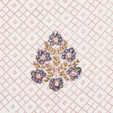 Detail of fabric in a lattice print with floral accents in pink, blue and green on a white field.