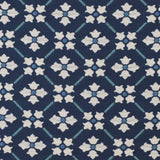 Detail of fabric in a repeating floral lattice print in blue and cream on a navy field.