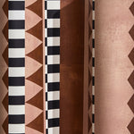 Wallpaper detail in bold geometric printed fabric in brown and tan with black and white accents.